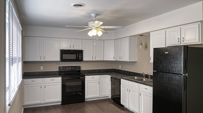 A Kitchen with White Cabinets and a Black Refrigerator
