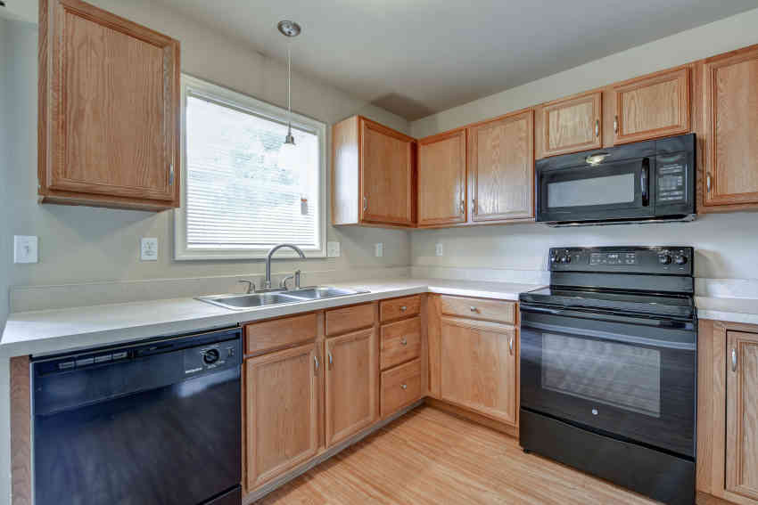 a kitchen with black appliances and wooden cabinets