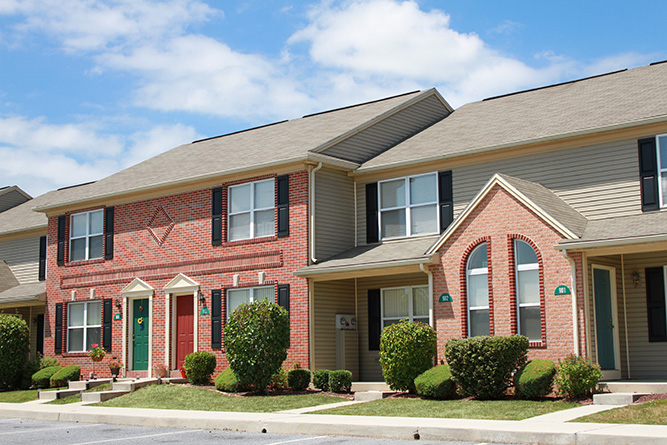 a brick apartment building with a green door