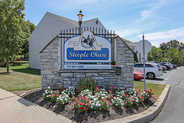 a sign for steeple chase is surrounded by flowers