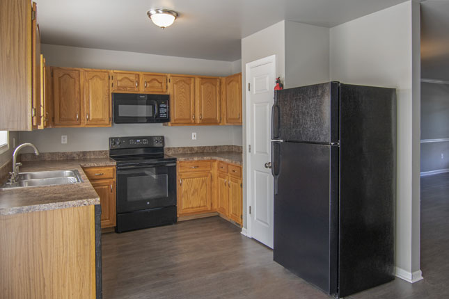 a kitchen with a black refrigerator stove and microwave