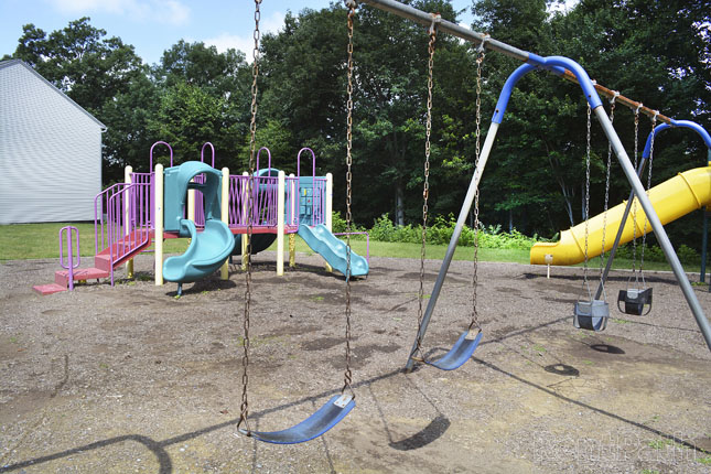 an empty playground with swings and a slide