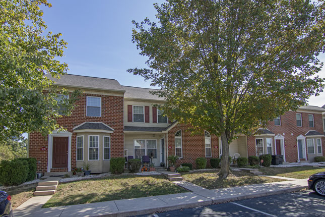 a brick house with a car parked in front of it