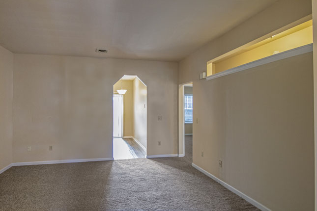 an empty room with a carpeted floor and beige walls