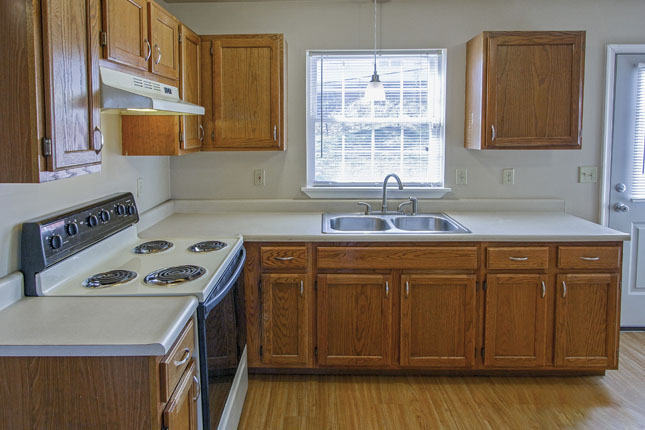 a kitchen with a stove top oven and a sink