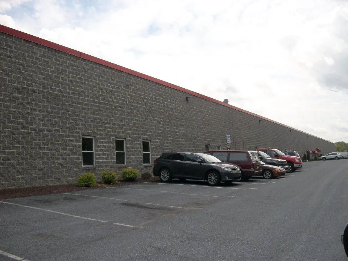 A Row of Cars are Parked in Front of a Brick Building