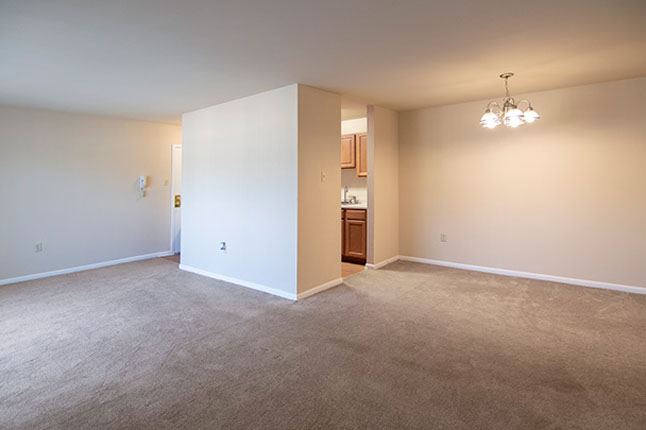 an empty room with a chandelier hanging from the ceiling