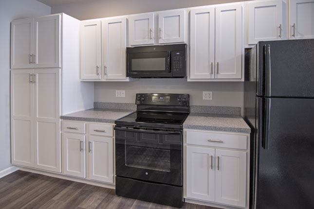 A Kitchen with White Cabinets and a Black Refrigerator
