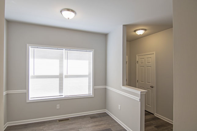 an empty room with a window and a door