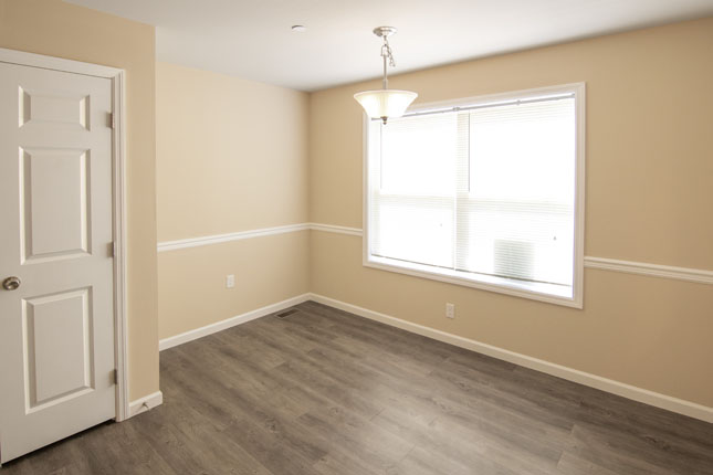 an empty room with a window and a chandelier