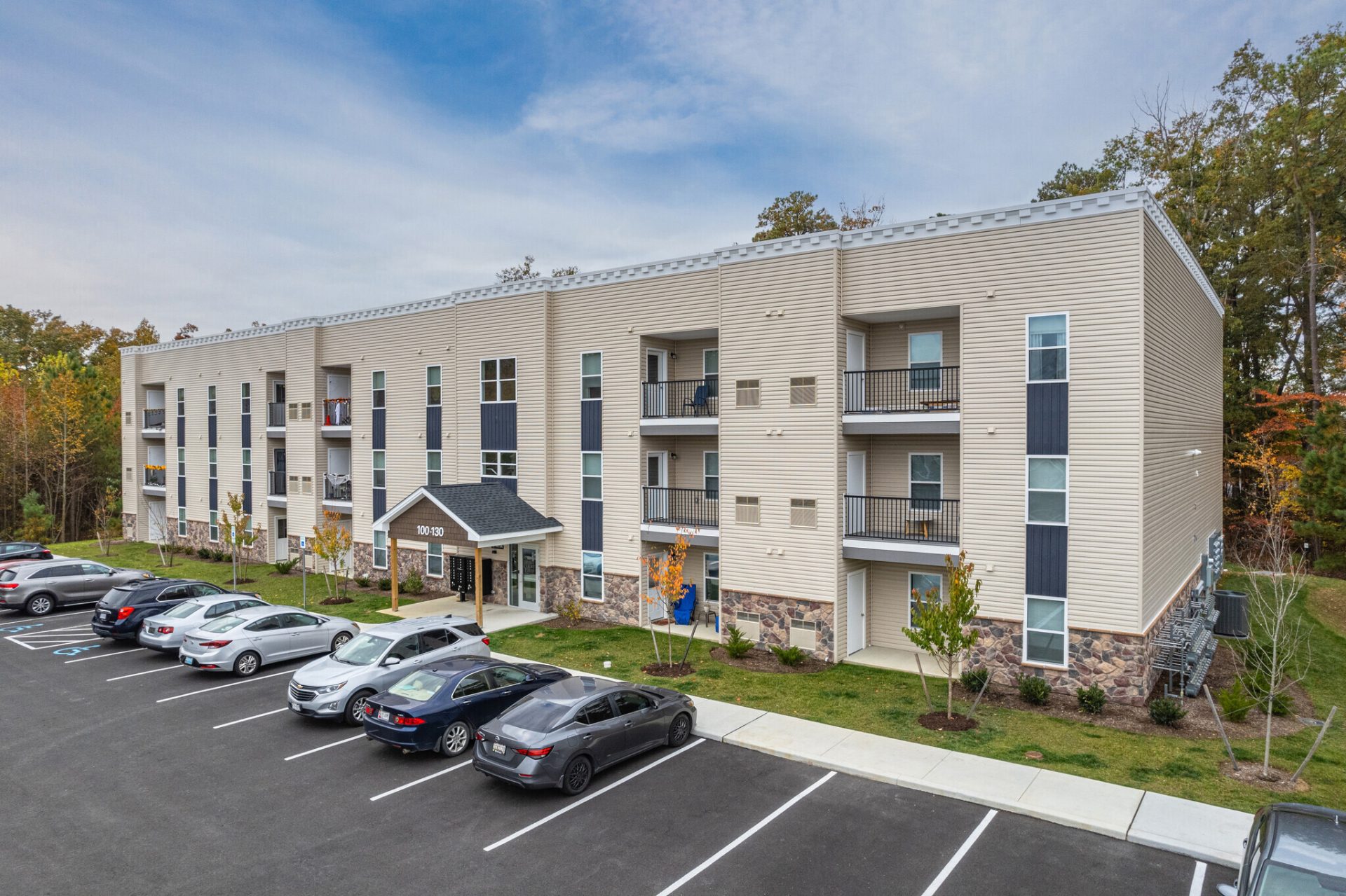 a large apartment building with cars parked in front of it