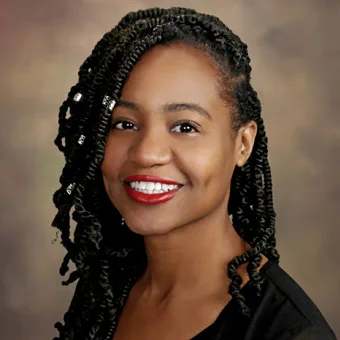 a woman with braids and red lipstick is smiling for the camera