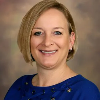 the woman is wearing a blue shirt and smiling for the camera