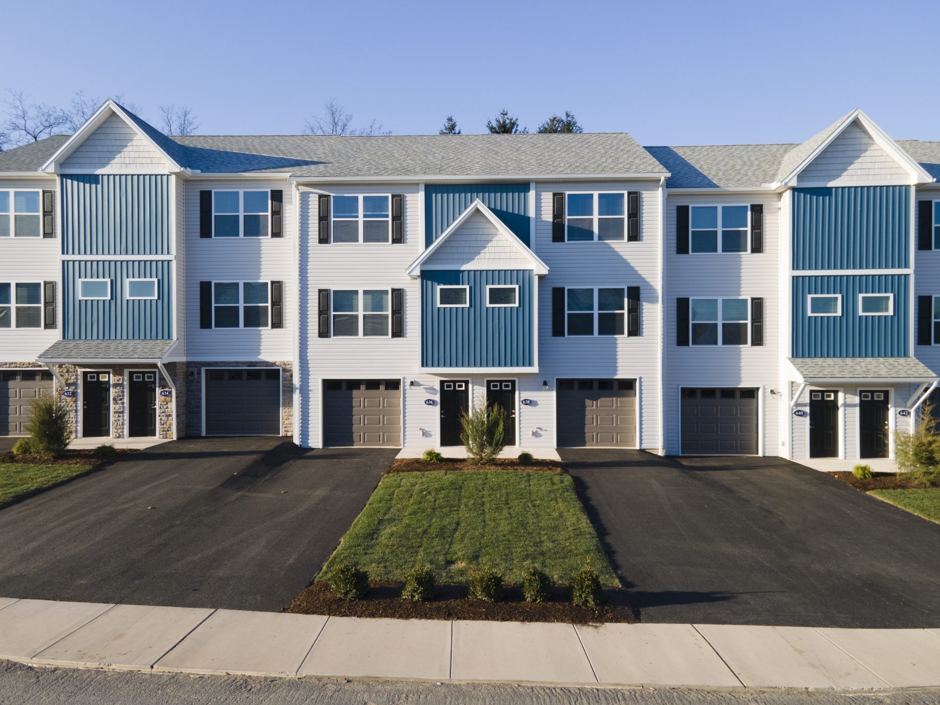 a row of apartment buildings with blue and white siding