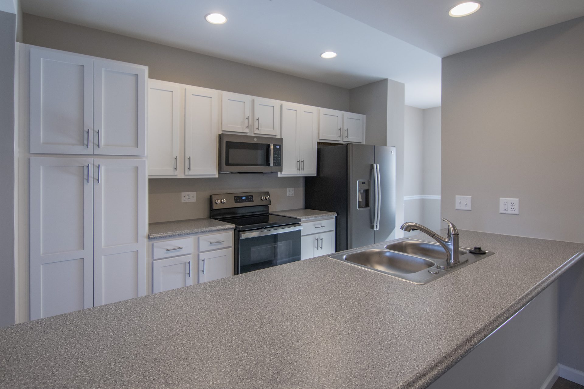 a kitchen with white cabinets and stainless steel appliances