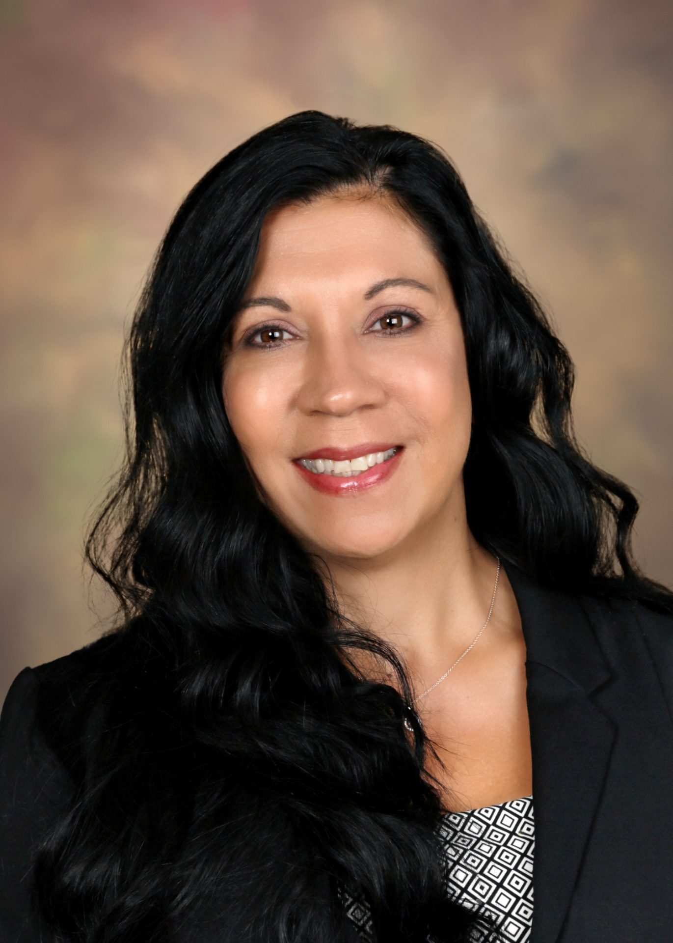 a woman with long dark hair is smiling for the camera