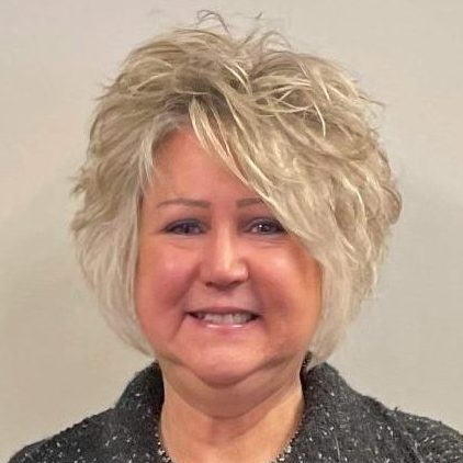 a woman with blonde hair and a black jacket is smiling for the camera